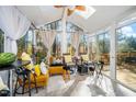 Bright sunroom with vaulted ceilings, skylights, large windows, and tile flooring, offering serene views at 104 Full Moon Ct, Garner, NC 27529