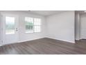 Bright, empty room with modern gray floors, white trim and a door to the outside at 11320 International Dr, Middlesex, NC 27557