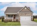 Charming home featuring a stone-accented facade, a welcoming porch, and an attached two-car garage at 11360 International Dr, Middlesex, NC 27557