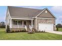 Charming home featuring a stone-accented facade, a welcoming porch, and an attached two-car garage at 11360 International Dr, Middlesex, NC 27557