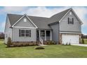 Charming two-story home with gray siding, brick accents, and a manicured lawn at 11376 International Dr, Middlesex, NC 27557