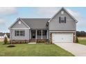 Charming two-story home with gray siding, brick accents, and a manicured lawn at 11376 International Dr, Middlesex, NC 27557