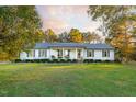 Ranch home with front porch, rocking chairs, tidy landscaping, and symmetrical curb appeal at 185 Franklin Ln, Henderson, NC 27537