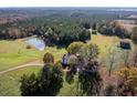 An aerial view of a charming home and acreage with a pond and barn at 206 Pike Memory Ln, Staley, NC 27355
