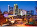 Downtown cityscape at night featuring the skyline, a bridge, and cars with light trails showcasing city life at 220 Augusta Pond Way # 126, Raleigh, NC 27603