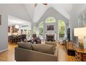 Bright living room with fireplace and tall, arched windows with views of the private outdoor space at 2725 Penfold Ln, Wake Forest, NC 27587