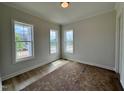 Bright bedroom with three large windows offering a view of the outdoors at 6044 Scalybark Road, Durham, NC 27712