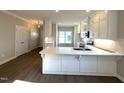 Kitchen featuring white cabinets, stainless steel appliances, hardwood floors and a large island with stone countertops at 180 Brunswick Dr, Nashville, NC 27856