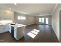 Open concept floor plan featuring kitchen with white cabinets and spacious living room with hardwood floors and ample natural light at 180 Brunswick Dr, Nashville, NC 27856