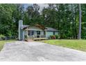 Quaint single-story home with a concrete driveway surrounded by lush greenery at 2704 Ross Rd, Durham, NC 27703