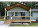 Inviting front porch with new wooden deck, decorative door, and updated lighting fixtures at 2704 Ross Rd, Durham, NC 27703