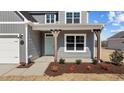Inviting front porch with decorative wood pillars, fresh landscaping, and a stylish teal door at 585 Husketh Rd, Youngsville, NC 27596