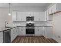 Modern kitchen featuring white cabinets, stainless steel appliances, and granite countertops at 585 Husketh Rd, Youngsville, NC 27596