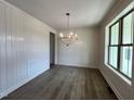 Formal dining room with wainscoting, dark wood floors, and large picture window at 6040 Scalybark Road, Durham, NC 27712