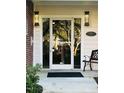 Inviting entrance with glass door, sconce lighting, bench and address plaque, blending elegance with comfort at 710 N Person St # 304, Raleigh, NC 27604