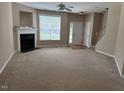 Spacious living room with plush carpeting, fireplace, and natural light from a large window at 4429 Log Cabin Dr, Raleigh, NC 27616
