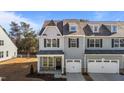 Modern two-story townhome with gray siding, white garage doors, and landscaping at 809 Pryor St, Mebane, NC 27302