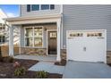 Modern front entry with dark door, stone accents, and white garage door at 809 Pryor St, Mebane, NC 27302