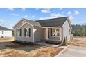 Gray exterior of charming one-story home with red door and landscaping at 145 Brookhaven Dr, Spring Hope, NC 27882