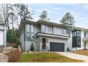 Contemporary two-story home featuring large windows, a gray facade, and a dark garage door at 2417 Mayview Rd, Raleigh, NC 27607