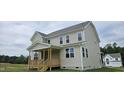 Rear exterior featuring siding, many windows and a charming back porch perfect for outdoor relaxation at 271 White Azalea Way, Homesite 30, Benson, NC 27504