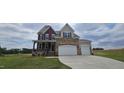 Beautiful two-story home featuring stone accents, a two-car garage, and a well-manicured front lawn at 271 White Azalea Way, Homesite 30, Benson, NC 27504