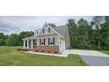 Beautiful home exterior featuring a well-manicured lawn and a two-car garage at 294 White Azalea Way, Homesite 74, Benson, NC 27504