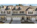 Three-unit townhome building, gray and beige siding, two-car garages at 811 Pryor St, Mebane, NC 27302