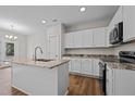 Modern kitchen with white cabinets, granite countertops, and stainless steel appliances at 813 Pryor St, Mebane, NC 27302