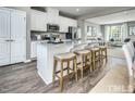Modern kitchen with white cabinets, granite countertops, and an island at 2103 Pitchfork Ln, Durham, NC 27713