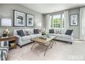 Bright living room with neutral walls, comfy sofas, and a coffee table at 2103 Pitchfork Ln, Durham, NC 27713