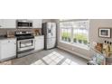 Well-lit kitchen with stainless steel appliances, white cabinets, and large window at 610 Canyon Lake Cir, Morrisville, NC 27560