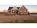 Inviting brick home with a covered porch, complemented by fresh landscaping and a sprawling green lawn at 7553 Sweetwater Dr, Nashville, NC 27856