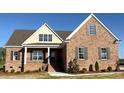 Charming brick home with covered porch and manicured landscaping, offering curb appeal at 7553 Sweetwater Dr, Nashville, NC 27856