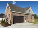 Attached garage with large doors, brick construction, and durable concrete driveway at 7553 Sweetwater Dr, Nashville, NC 27856
