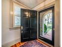 Open entryway with a dark front door and a glimpse of the charming brick pathway outside at 205 N Boundary St, Chapel Hill, NC 27514