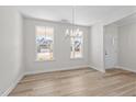 Bright dining room with wood floors, natural light, and a modern chandelier at 317 Highland Ridge Ln, Knightdale, NC 27545
