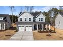 Charming two-story home with gray siding, a welcoming front porch, and a two-car garage at 317 Highland Ridge Ln, Knightdale, NC 27545