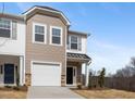 Inviting townhome with stone accents, a one-car garage, and a classic exterior color scheme at 53 Lavender Ln, Clayton, NC 27520