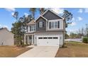 Charming two-story home featuring a two-car garage, landscaped yard, and inviting covered porch at 60 Bennett Rd, Coats, NC 27521