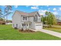 Well maintained two-story home with a two-car garage, landscaped front yard, and a mix of gray and light gray siding at 60 Bennett Rd, Coats, NC 27521