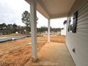 Covered porch with white columns, concrete floor, and view of surrounding construction at 60 Bennett Rd, Coats, NC 27521