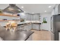 Modern kitchen features stainless steel appliances, grey cabinets, open shelving and light wood floors at 710 Spring Ln, Sanford, NC 27330