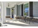 Charming front porch with stone accents, dark shutters, and space for seating at 232 Big Barn Dr, Wendell, NC 27591