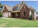 Elegant brick home showcasing detailed landscaping, a two-car garage, and a covered front entrance at 2502 St Marys St, Raleigh, NC 27609