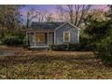 Gray house with small front porch, surrounded by trees and autumn leaves at 4505 Laymans Chapel Rd, Durham, NC 27704