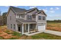 Two-story home features a covered porch with white columns and a two-car garage with a long concrete driveway at 9184 Phoenix Ct, Middlesex, NC 27557