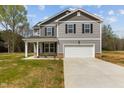 Two-story home features gray siding, white trim, and a spacious two-car garage with a long concrete driveway at 9184 Phoenix Ct, Middlesex, NC 27557