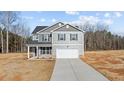 Charming two-story home featuring a gray exterior, a two-car garage, and a long concrete driveway at 9184 Phoenix Ct, Spring Hope, NC 27882