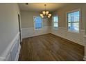 Bright dining room with hardwood floors, classic wainscoting, and a stylish chandelier at 1009 Bostonian Dr, Knightdale, NC 27545